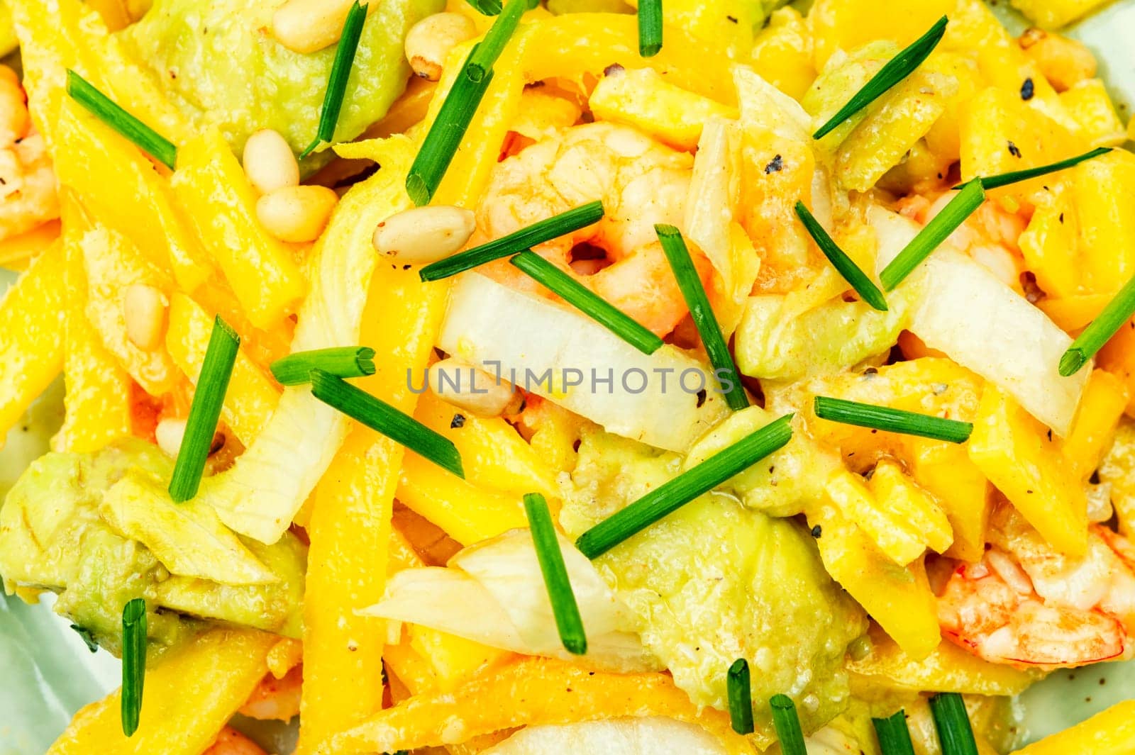 Delicious salad of mango, avocado, shrimp and pine nuts. Food background