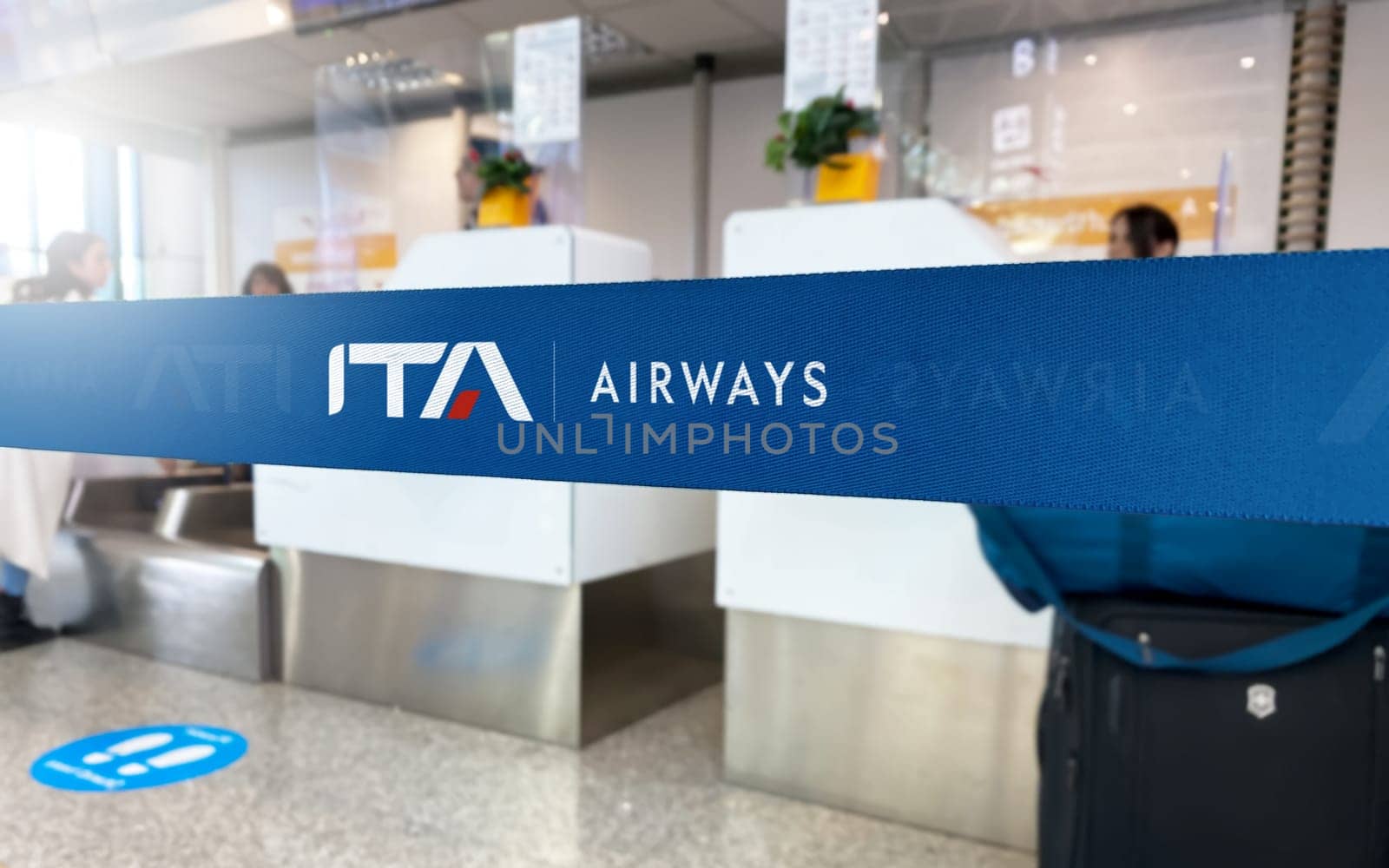 Rome, IT, Jan 2023: Blue barrier tape with the ITA Airways logo inside an airport. ITA Airways is the Italian flag carrier airline . Travel and airport security. Illustrative editorial