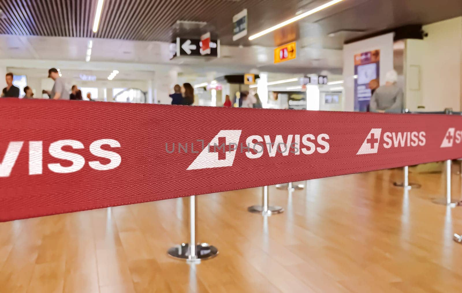 Zurich, CH, Feb 2023: Red barrier tape with the SWISS airlines logo inside an airport. SWISS is the national airline of Switzerland. Travel and airport security. Illustrative editorial