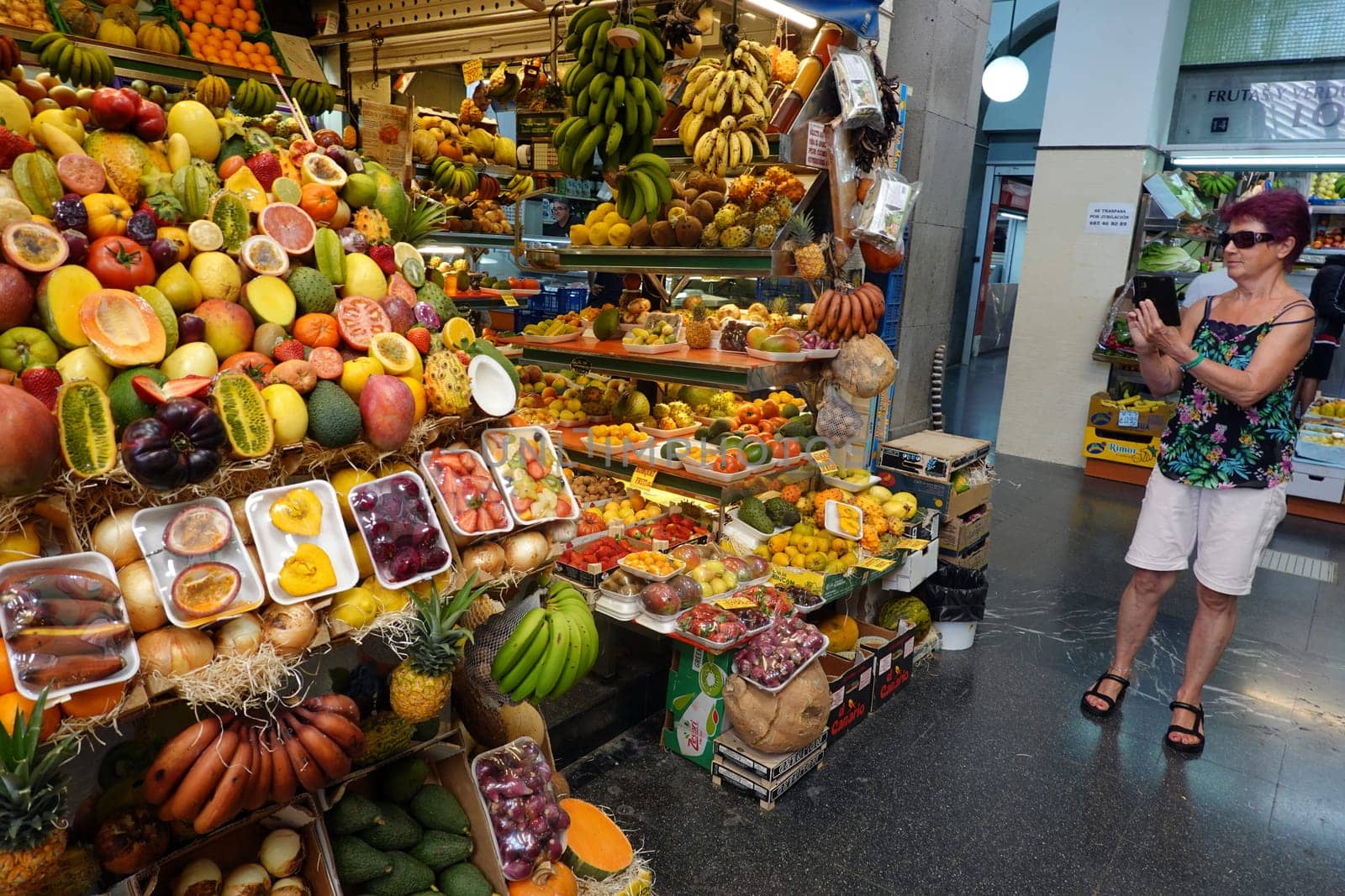 Touristin fotografiert überwätigendes Obst- und Gemüseangebot in der Markthalle Mercado de Vegueta, Gran Canaria, Spanien, Las Palmas