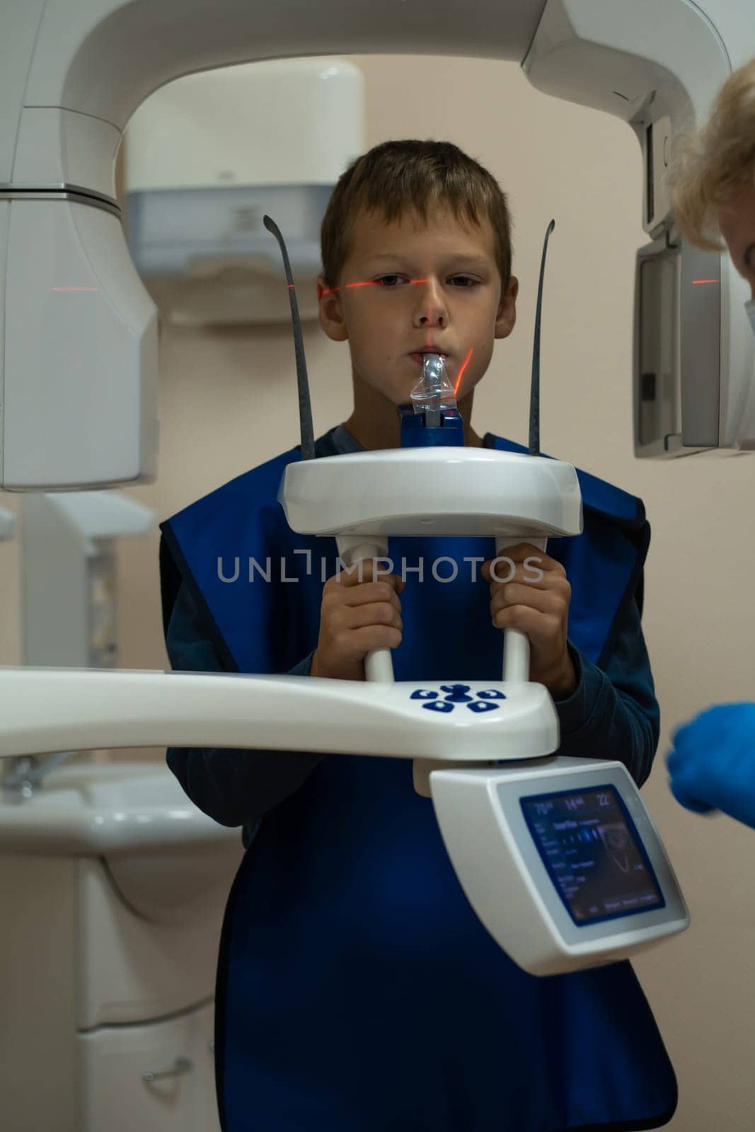 Jaw computed tomography, check up teeth in dental clinic. Little boy on x-ray diagnostics. Circular snapshot of jaw on modern medical equipment. CT scanning, stomatology and radiology.