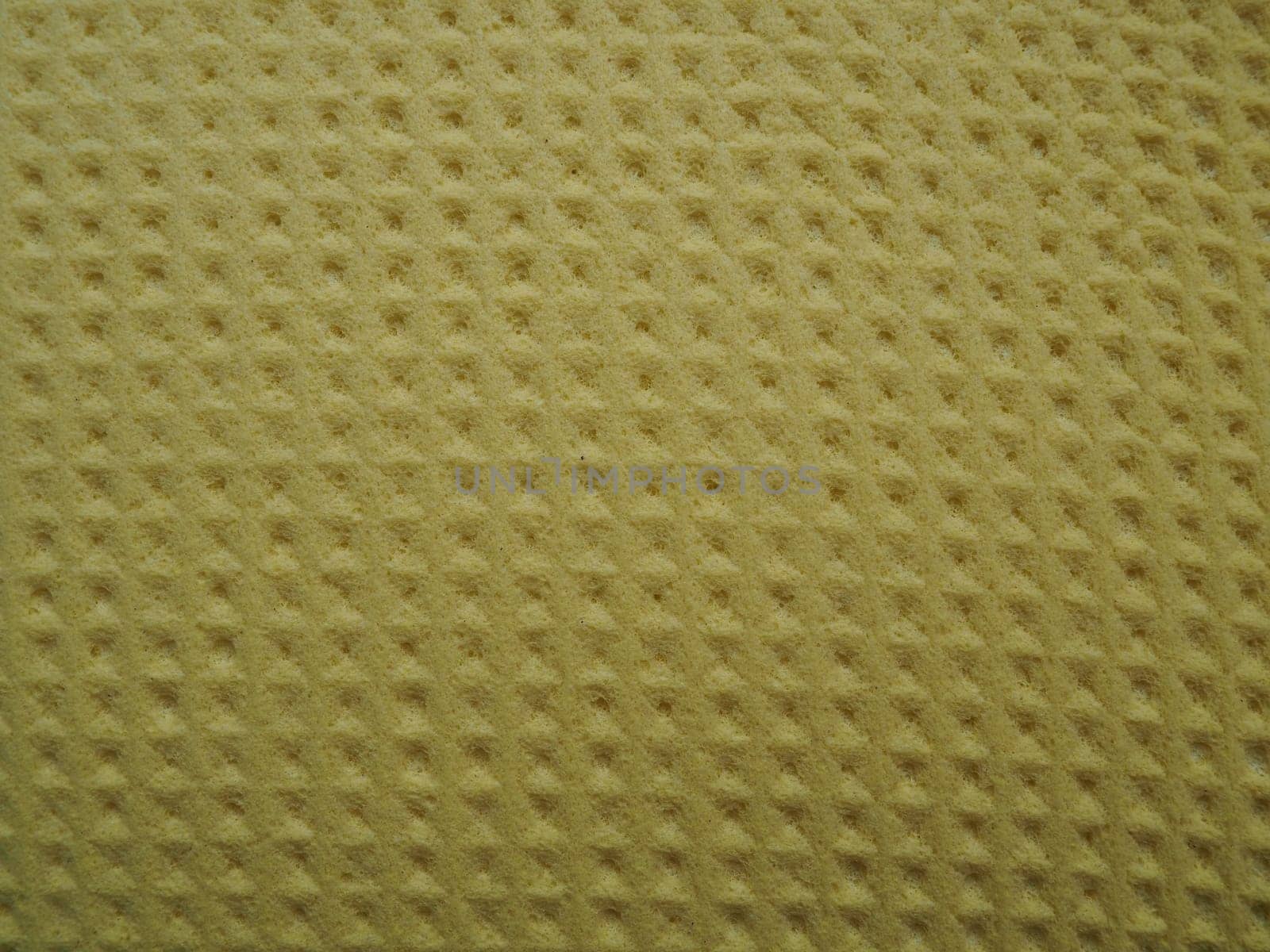 Sponge fibers sponge texture pattern surface close-up yellow brown background.