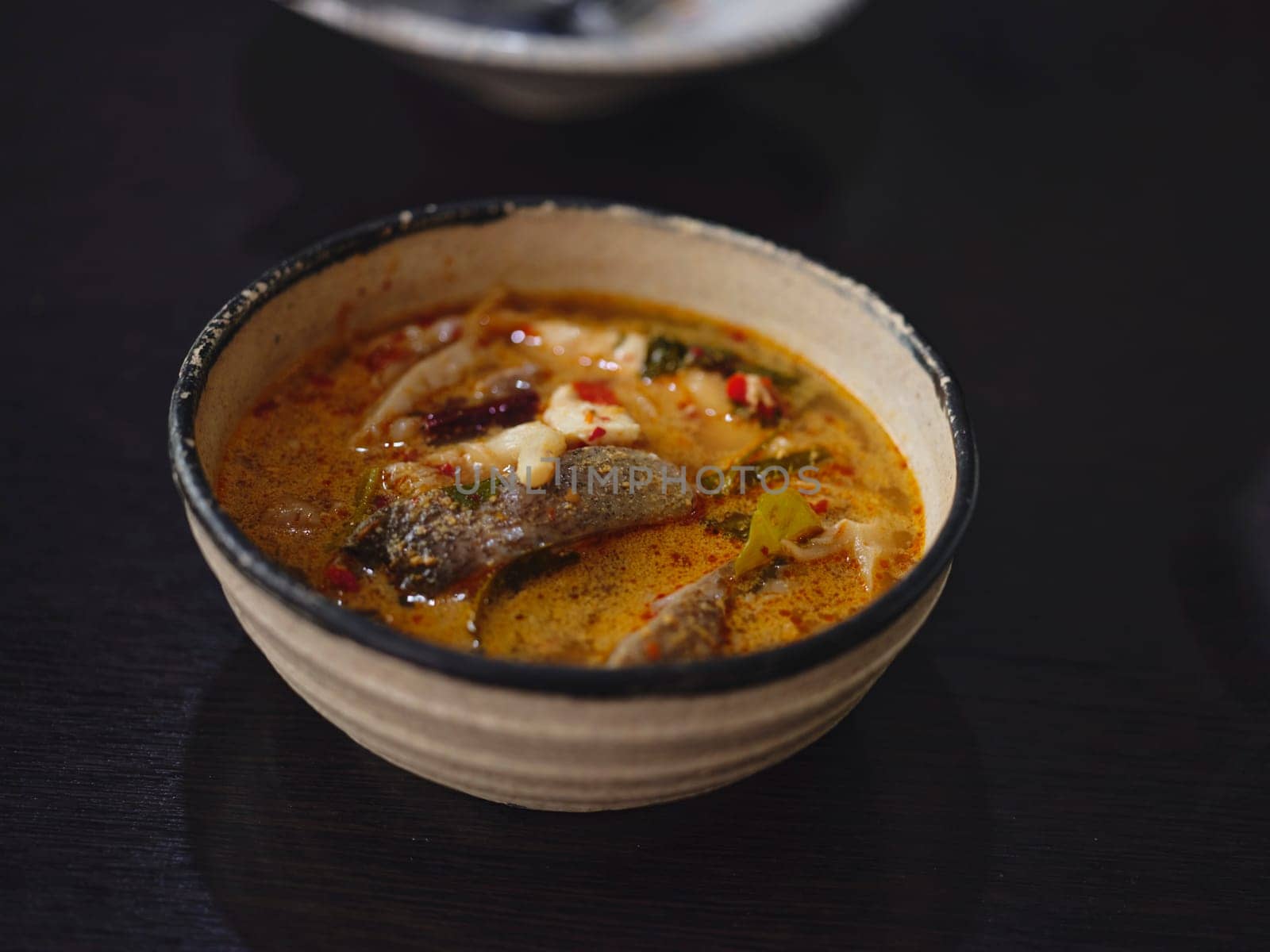 Traditional Thai soup Tom Yum with fish , coconut milk and chili pepper and rice bowl.