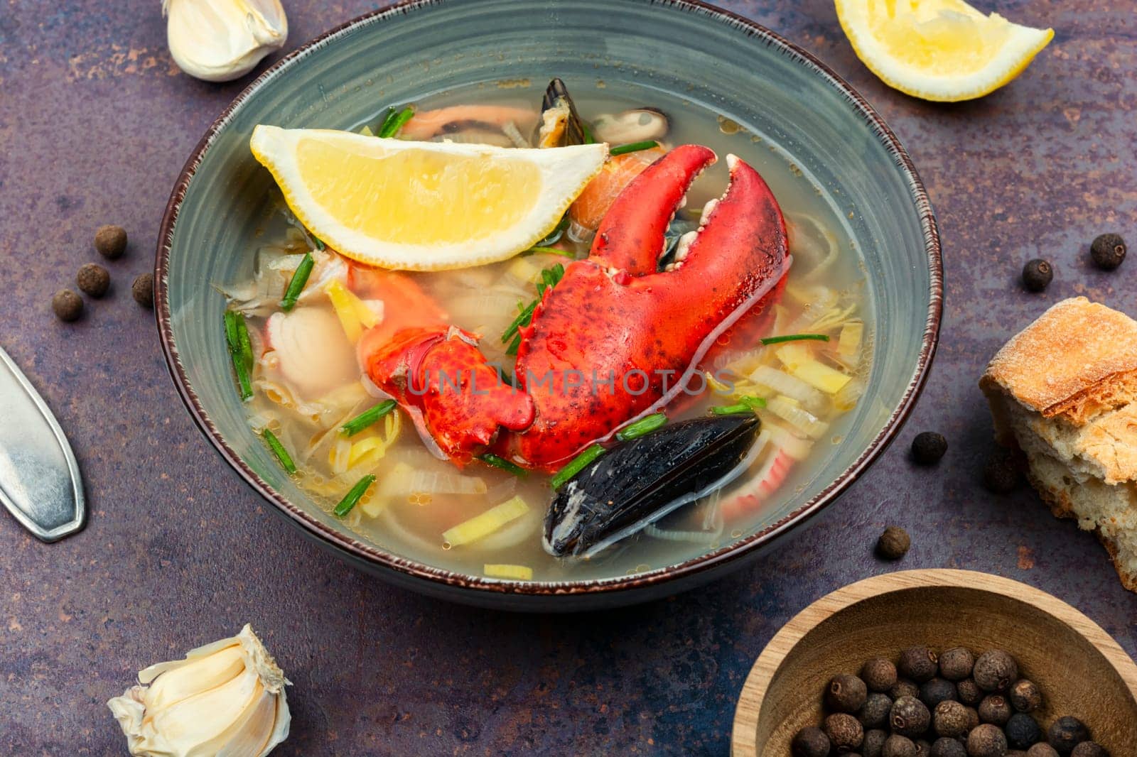 Seafood soup with lobster, mussels, shrimps and fish. Soup in ceramic bowl. Tom yum. Copy space