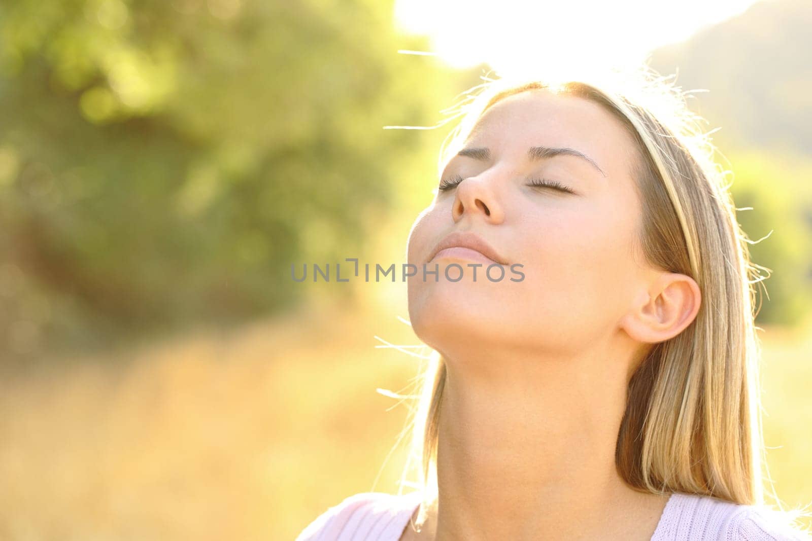 Relaxed beautiful woman breathing fresh air in nature