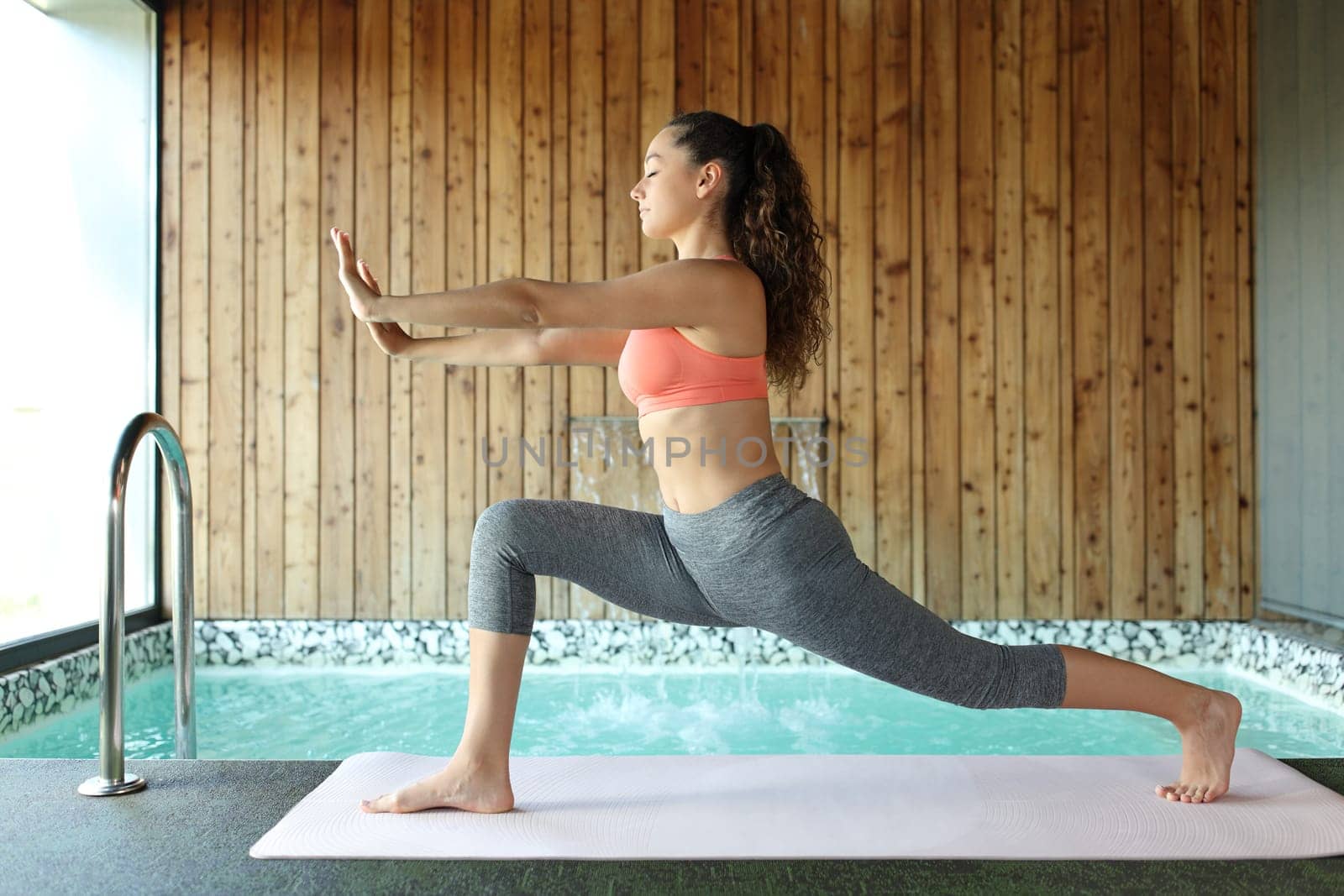 Single woman in spa doing tai chi exercises