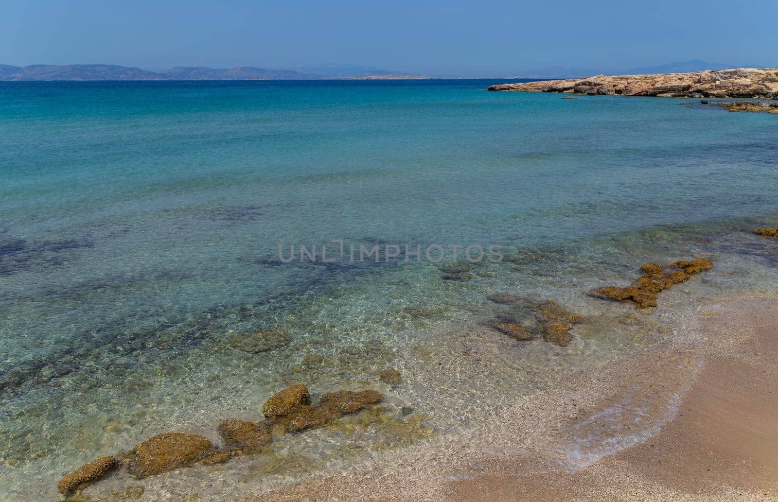 The coast of Aegina island with clear and blue waters of Mediterranean sea in the Saronic gulf, Greece.