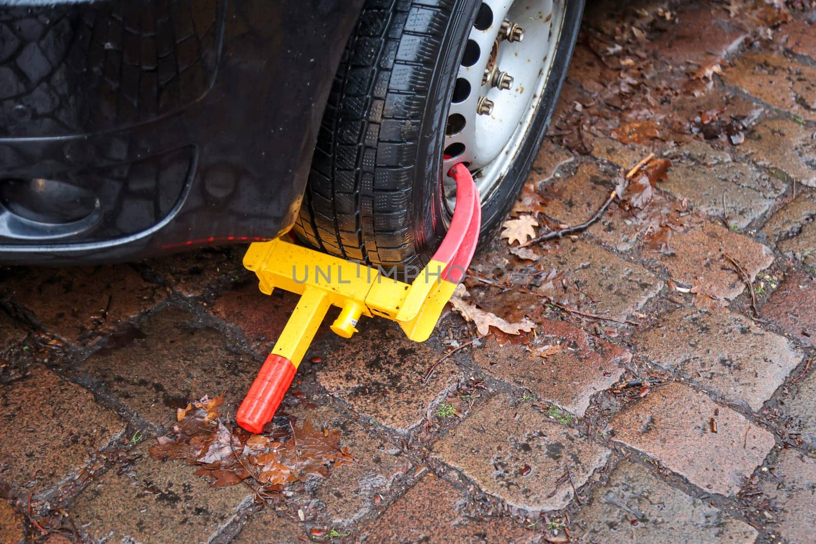 A car is prevented from moving forward by a parking claw, tire claw, immobilizer.