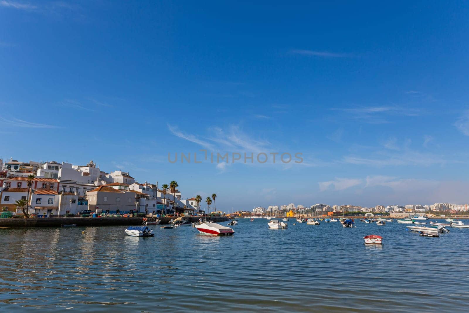 Ferragudo, Portugal - August 25, 2022 - View of the white town with boats moored in the foreground, Ferragudo, Algarve, Portugal, Europe