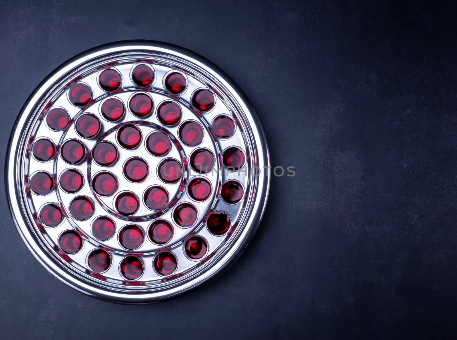 Communion glass cups on tray filled with wine the symbol of Jesus Christ blood on black background. Easter Passover and Lord Supper concept.