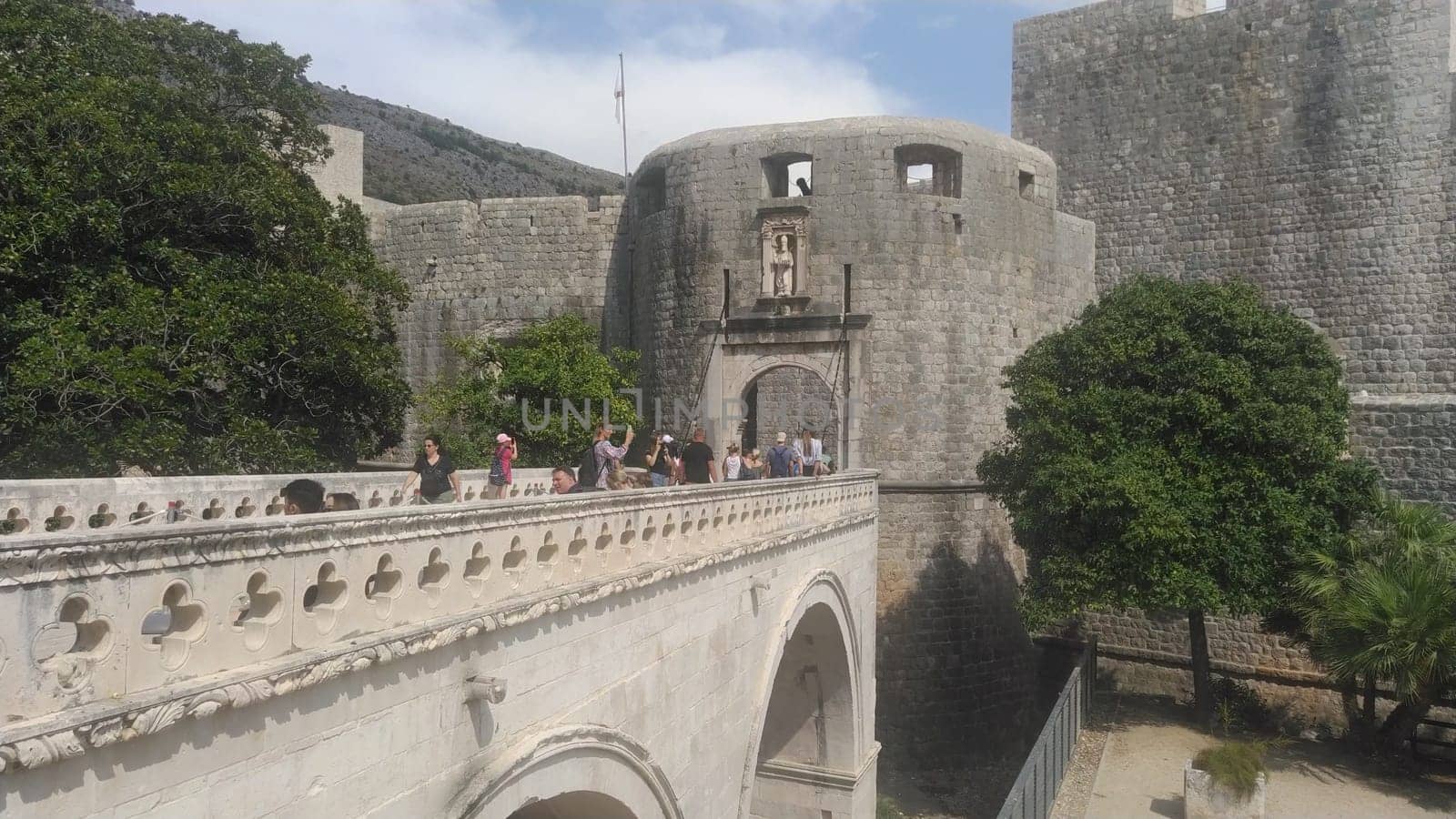 Pile Gate Dubrovnik Croatia August 14 2022 People men and women walk along the stone bridge to the gate of the Old City. Crowd of tourists. Busy entrance. The main entrance to Old Town, busy Pile Gate
