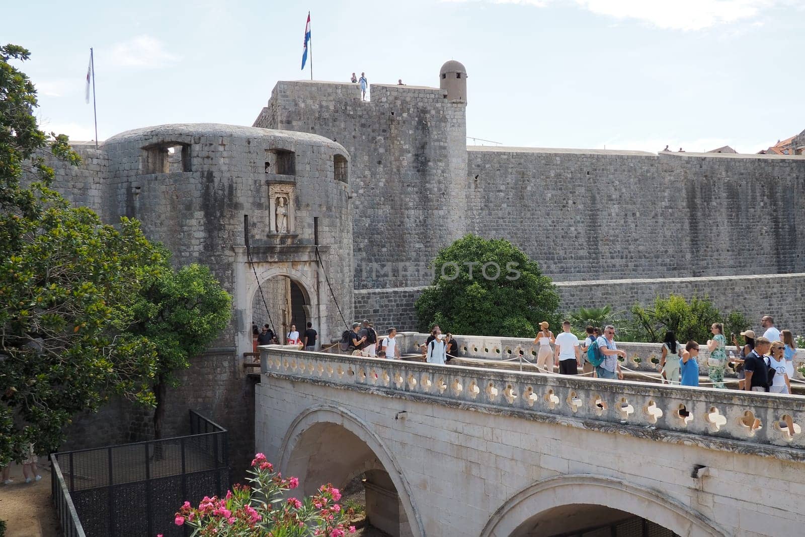 Pile Gate Dubrovnik Croatia August 14 2022 People men and women walk along the stone bridge to the gate of the Old City. Crowd of tourists. Busy entrance. The main entrance to Old Town, busy Pile Gate