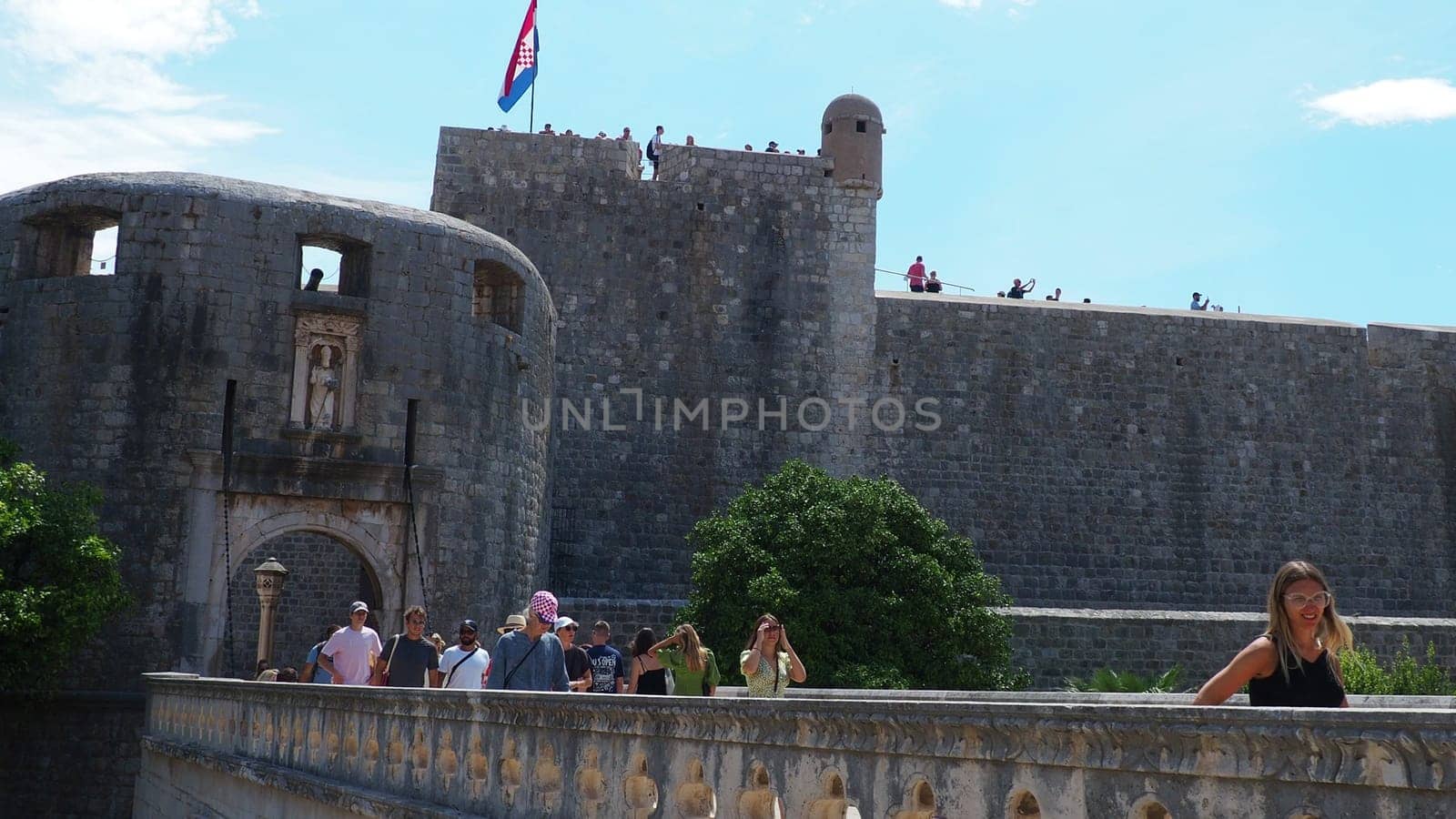 Pile Gate Dubrovnik Croatia August 14 2022 People men and women walk along the stone bridge to the gate of the Old City. Crowd of tourists. Busy entrance. The main entrance to Old Town, busy Pile Gate