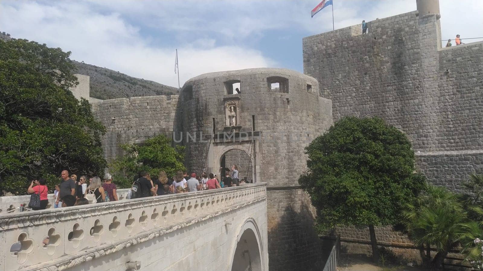 Pile Gate Dubrovnik Croatia August 14 2022 People men and women walk along the stone bridge to the gate of the Old City. Crowd of tourists. Busy entrance. The main entrance to Old Town, busy Pile Gate