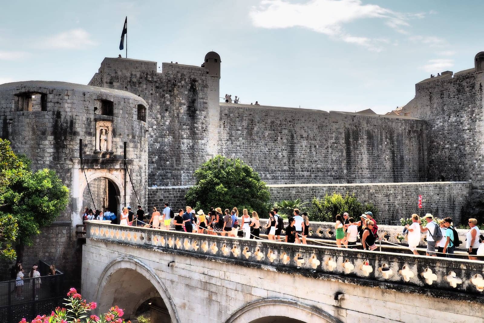 Pile Gate Dubrovnik Croatia August 14 2022 People men and women walk along the stone bridge to the gate of the Old City. Crowd of tourists. Busy entrance. The main entrance to Old Town, busy Pile Gate