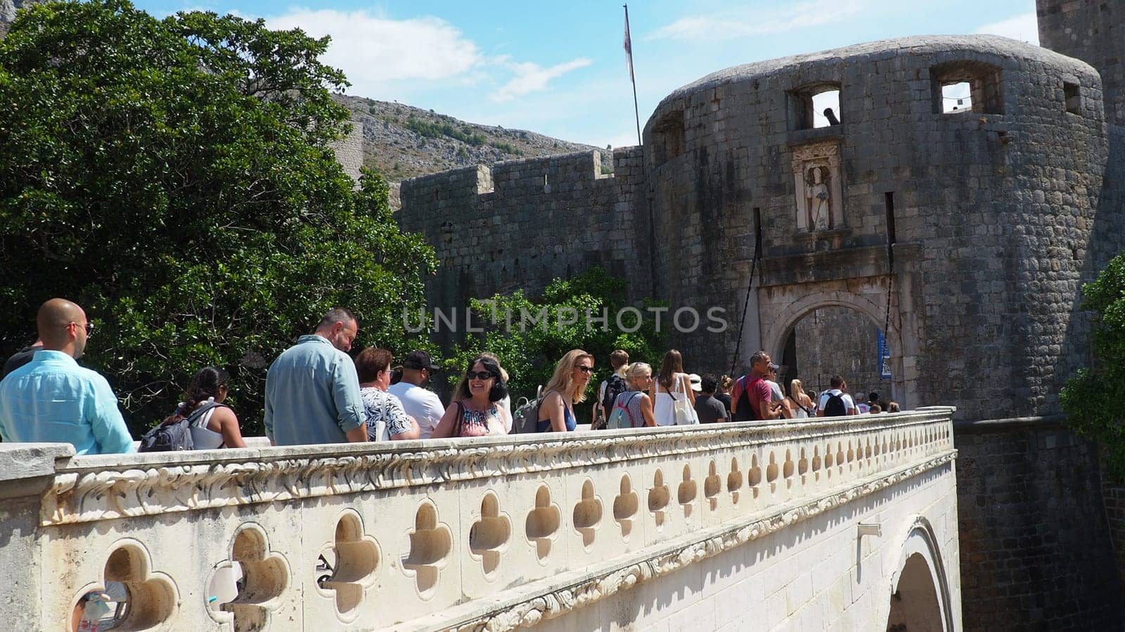 Pile Gate Dubrovnik Croatia August 14 2022 People men and women walk along the stone bridge to the gate of the Old City. Crowd of tourists. Busy entrance. The main entrance to Old Town, busy Pile Gate