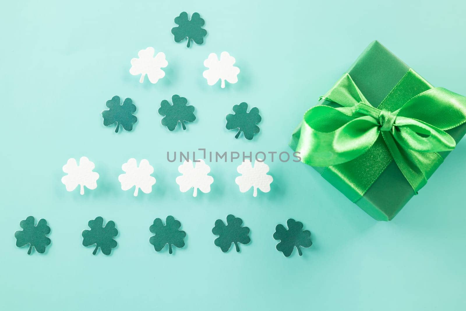 Happy St Patricks Day decoration background concept. shamrocks leaves holiday symbol with copy space on pastel background, above view gift box green clover leaves