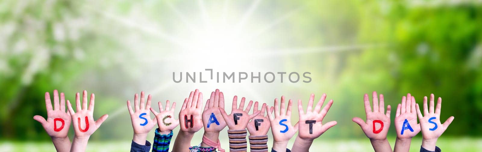 Children Hands Building Colorful German Word Du Schaffst Das Means You Can Do It. Sunny Green Grass Meadow As Background.