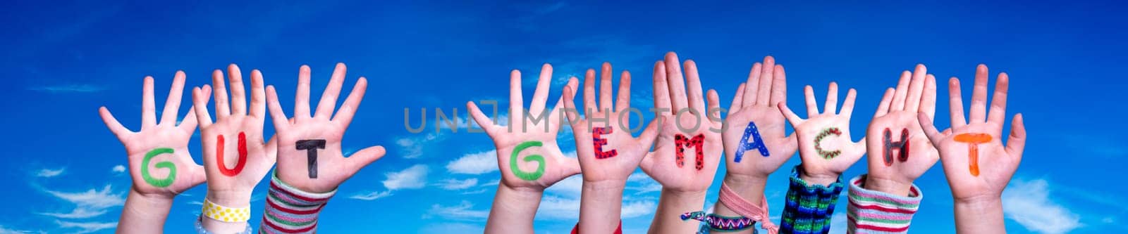 Children Hands Building Colorful German Word Gut Gemacht Means Well Done. Blue Sky As Background.