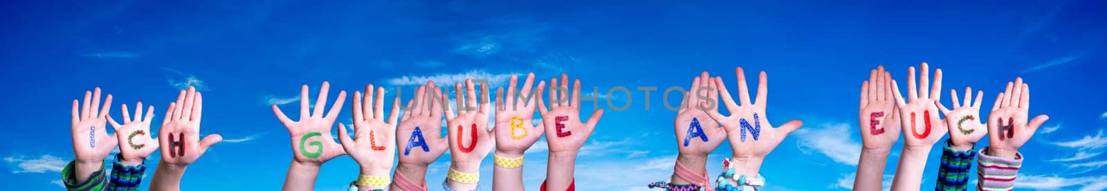 Children Hands Building Colorful German Word Ich Glaube An Euch Means I Believe In You. Blue Sky As Background.