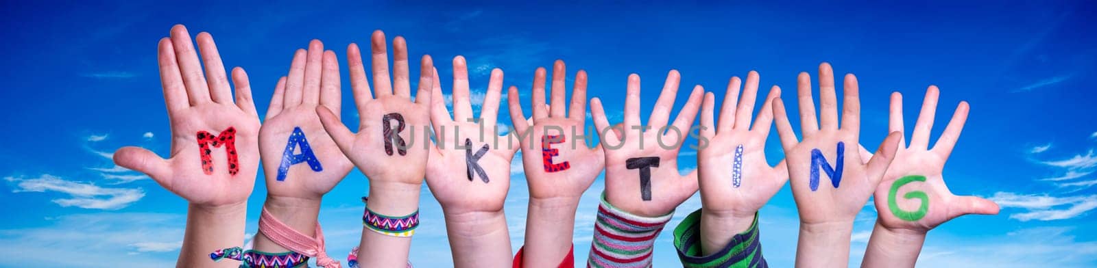 Children Hands Building Colorful English Word Marketing. Blue Sky As Background