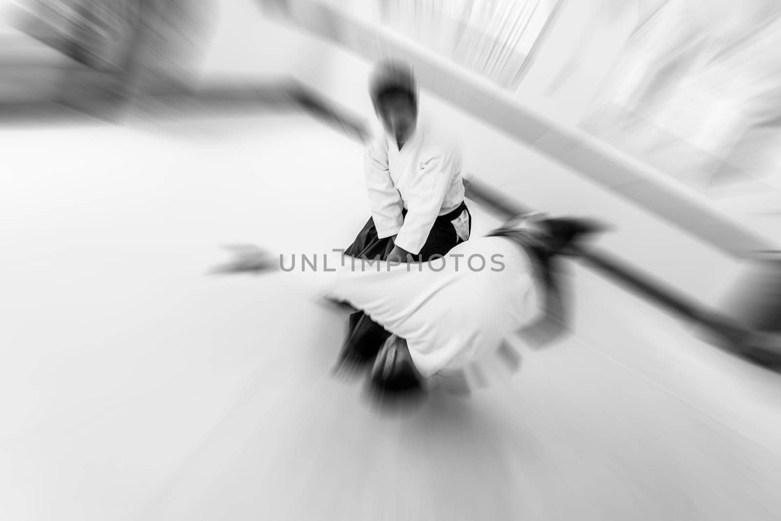 People practicing aikido martial art in a dojo background. Tobi ukemi.
