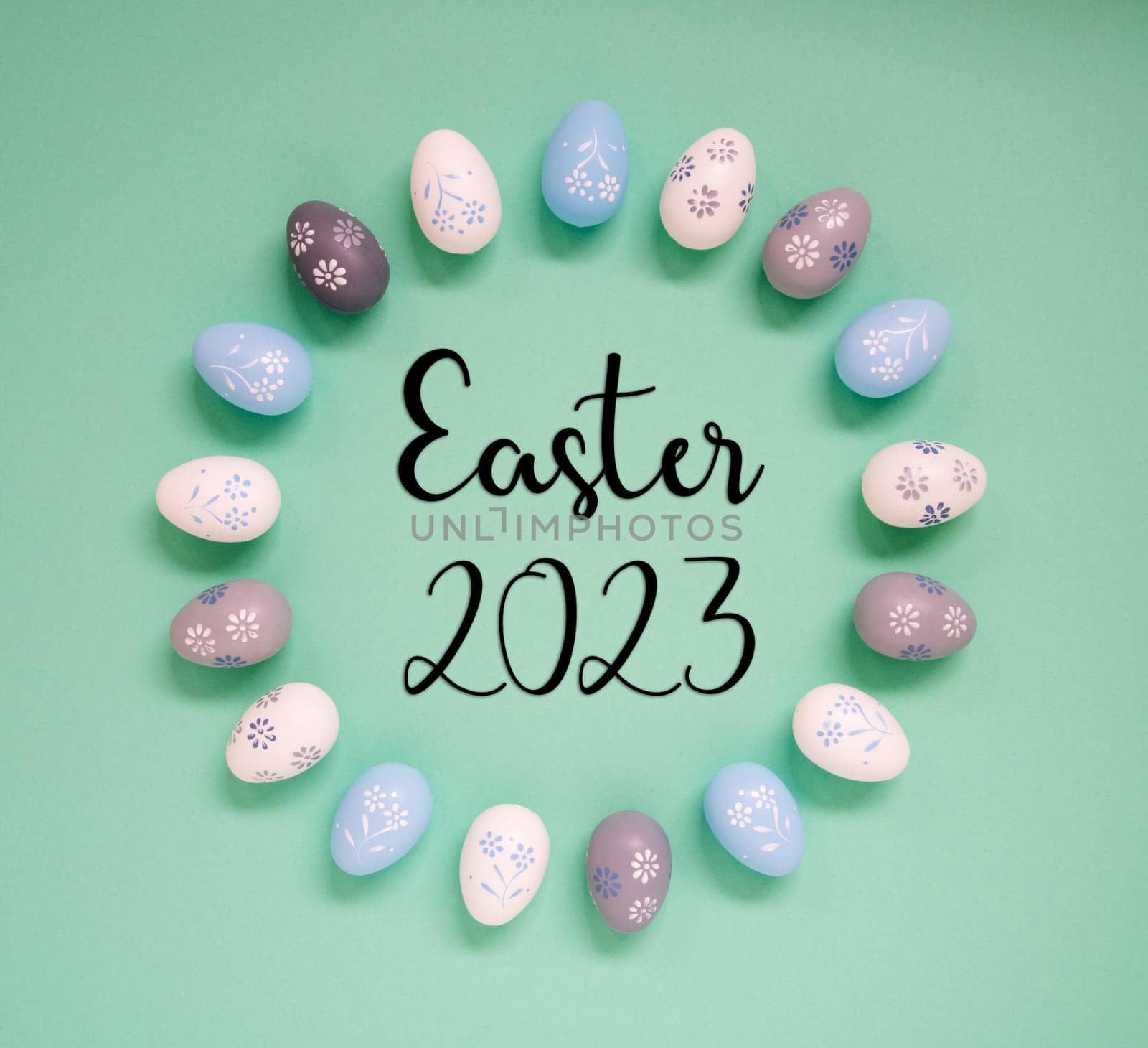 Flat Lay With English Text Easter 2023. Easter Egg Arrangement, Decoration And Ornament. Light Green Paper Background
