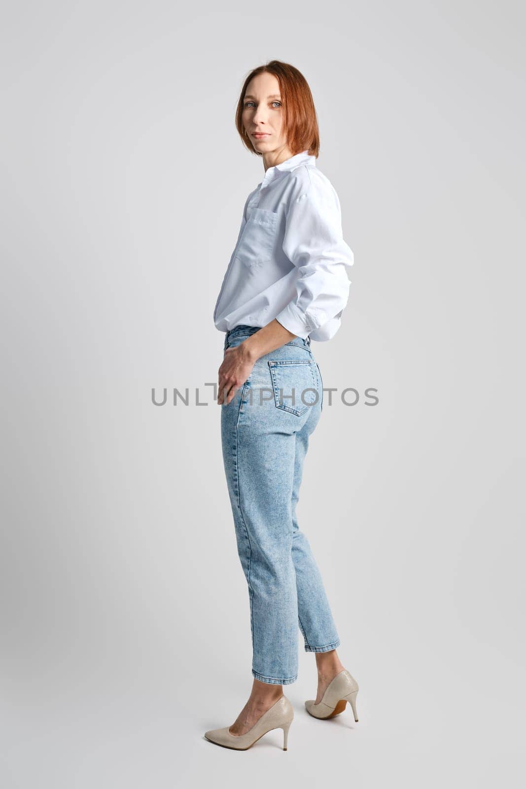 Middle aged redhead woman turning half back