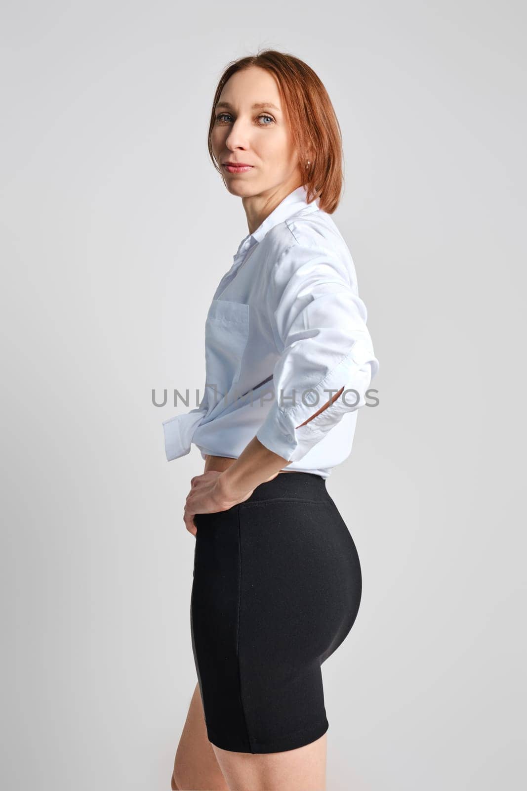 Portrait of adult woman in tight mini skirt and white shirt in profile