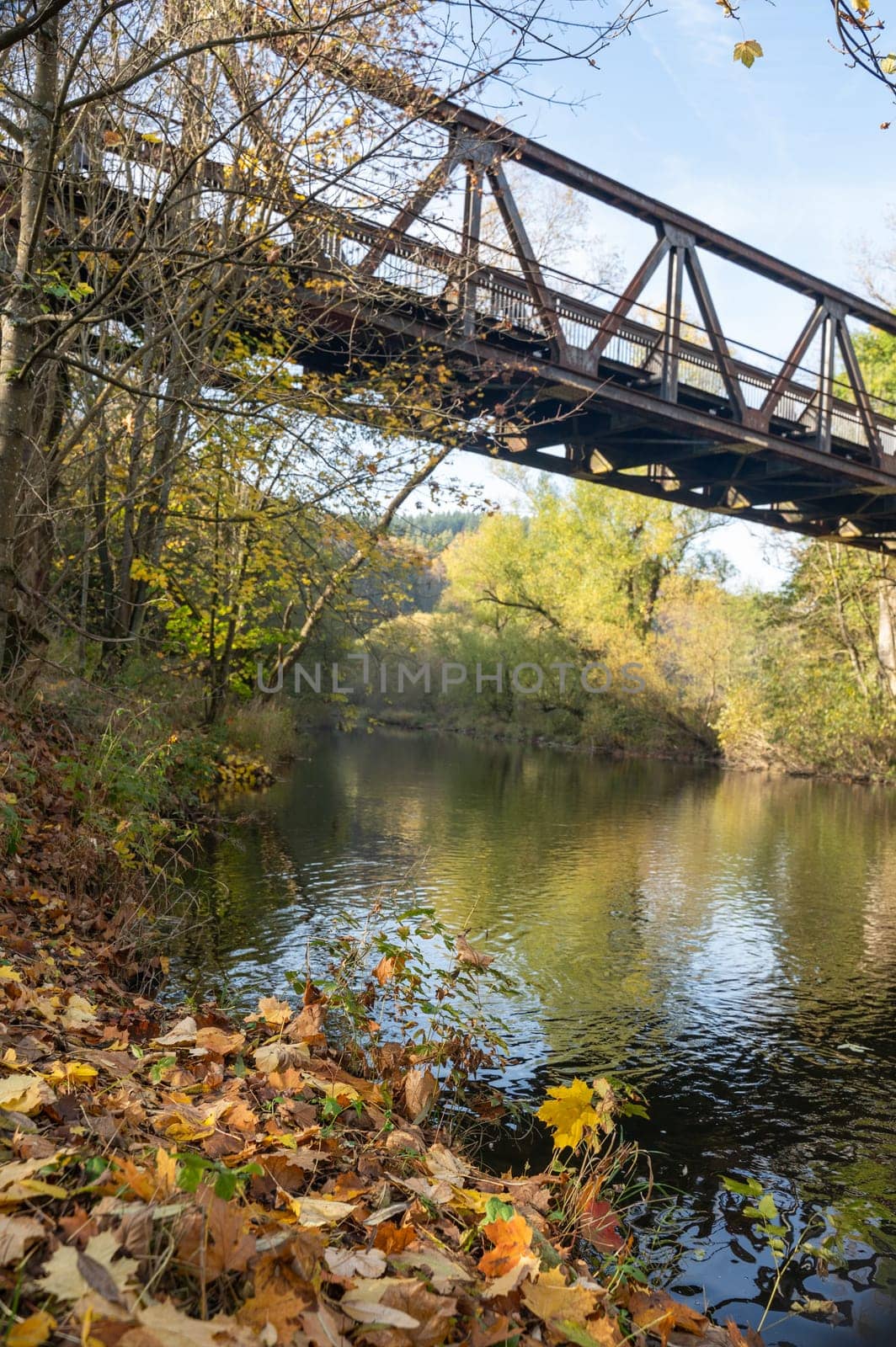Old iron bridge over the river Eder with banks and trees in Hesse, Germany, Europe