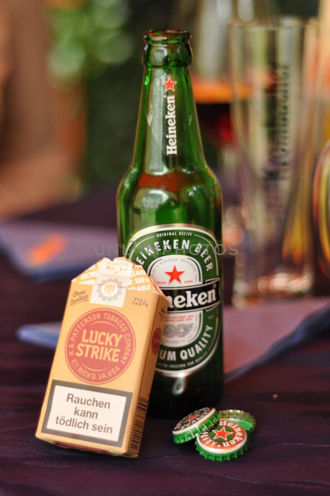 Box of Lucky Strike cigarettes without additives in front of a Heineken beer bottle