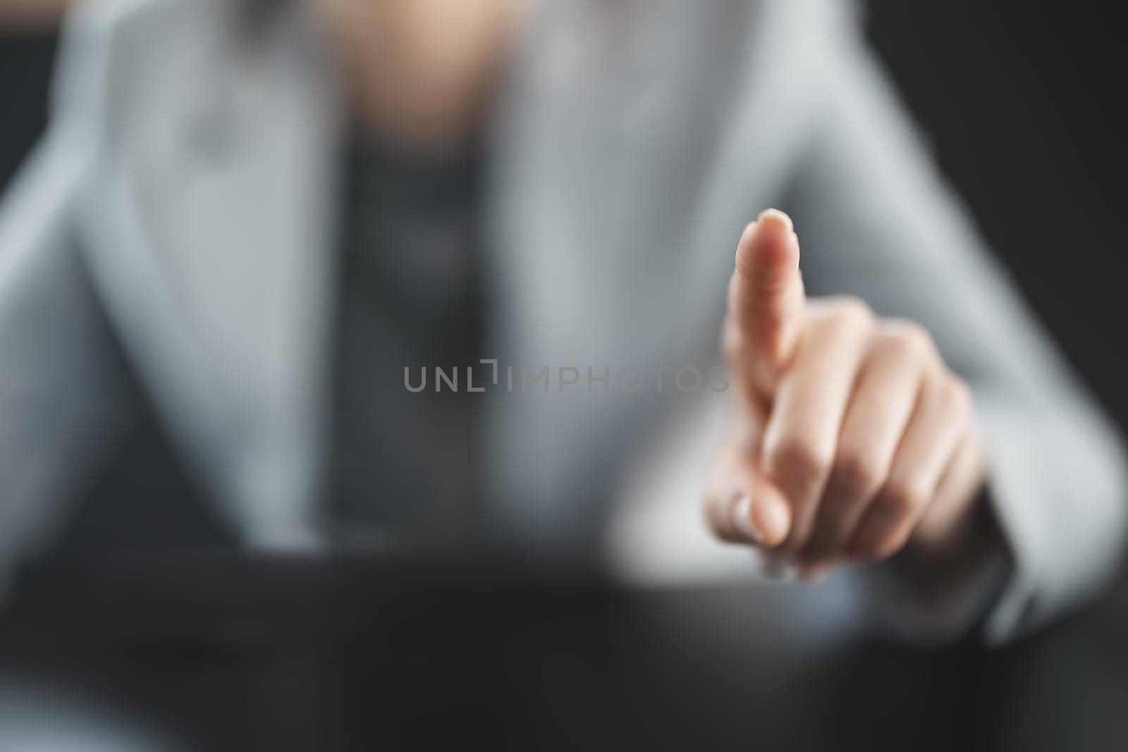 Businesswoman sitting at the black table and pointing by finger. Concept of the leadership and business owner.