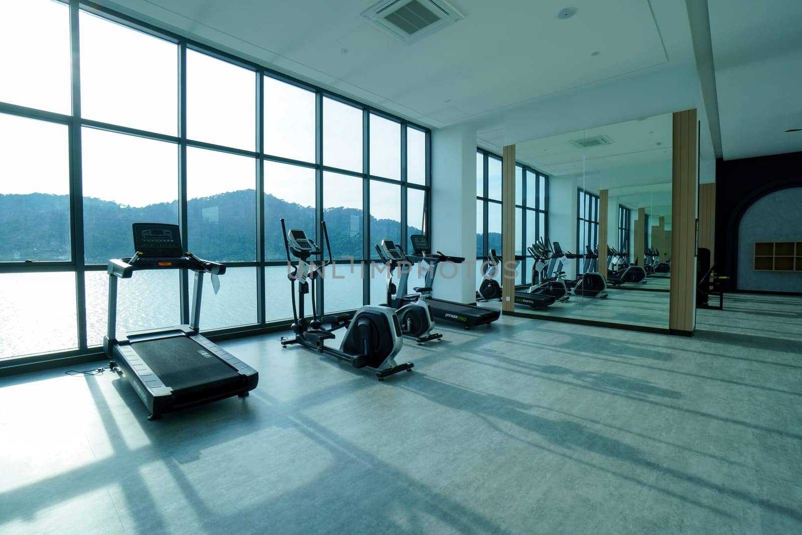 Bayan Lepas, Penang, Malaysia - Nov 16 2021: Group of running machine with shadow from the sun in gym room