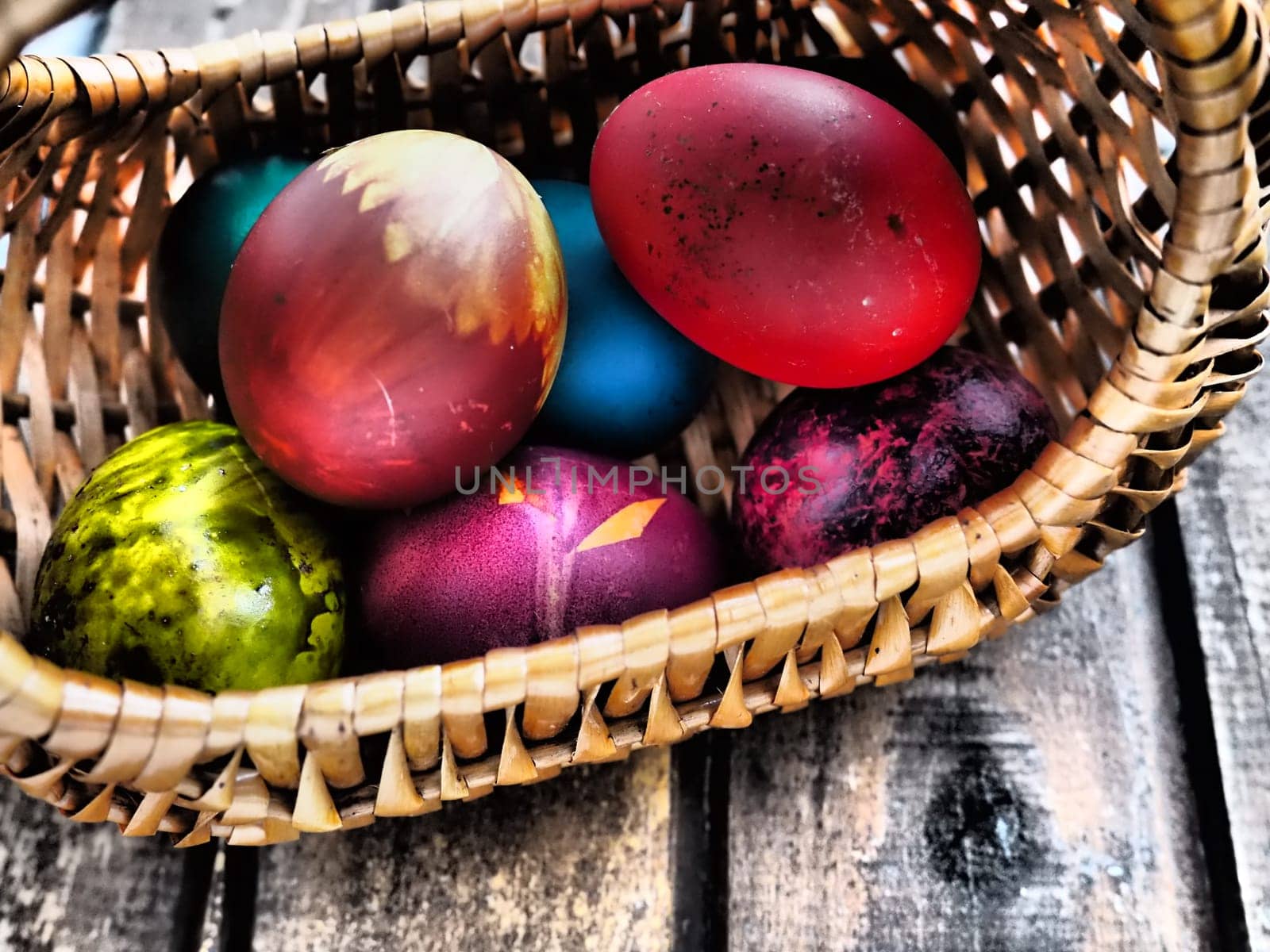 Happy Easter. Easter colored eggs in a wicker basket on a wooden table. Easter, the Resurrection of Christ, the Bright Resurrection of Christ, the most ancient and Christian holiday