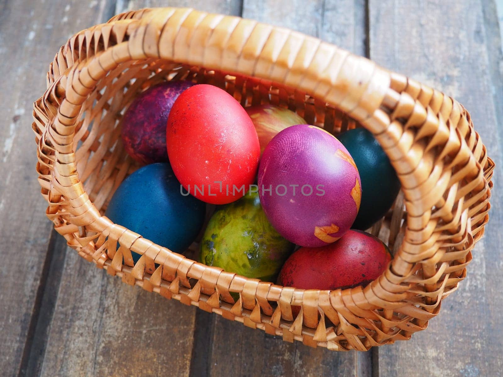 Happy Easter. Easter colored eggs in a wicker basket on a wooden table. Easter, the Resurrection of Christ, the Bright Resurrection of Christ, the most ancient and Christian holiday
