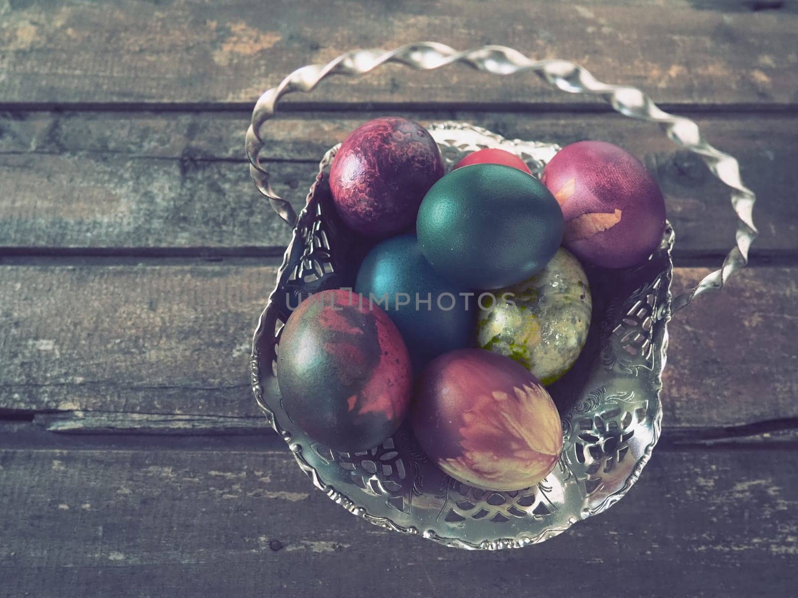 Easter colored eggs in an old metal candy bowl on a wooden table. Easter, the Resurrection of Christ, the Bright Resurrection of Christ, the most ancient and Christian holiday.