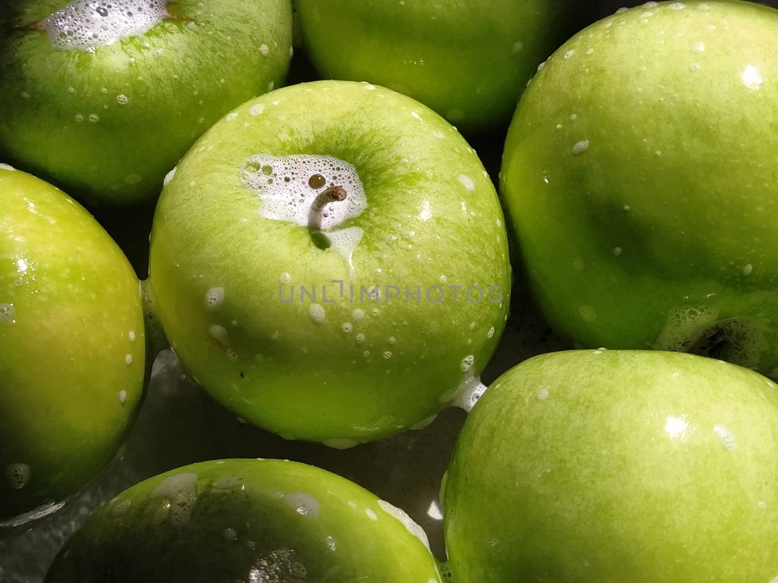 green apples, soaped and ready to rinse with water. Good hygiene when eating food.