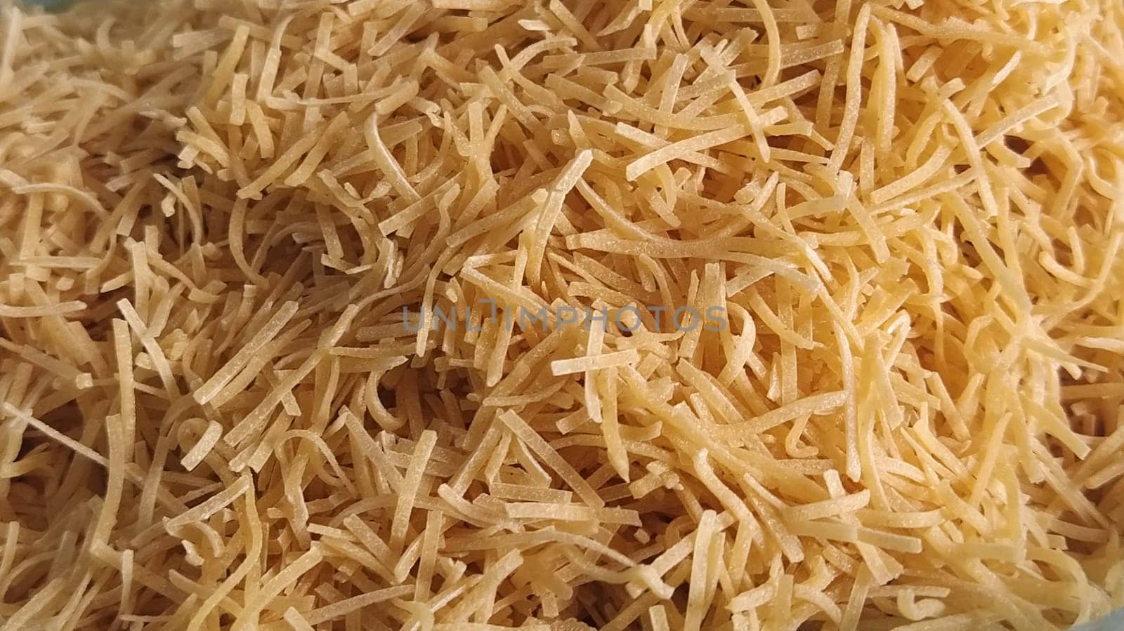 Thin dry vermicelli. Wheat flour product containing gluten, vitamins, carbohydrates, proteins and fats. Small pasta close-up. Fast food
