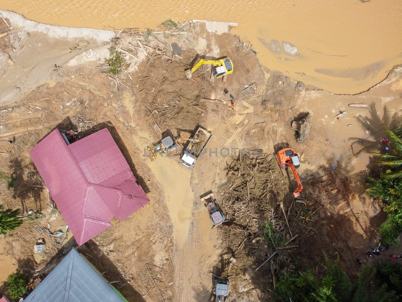 Baling, Kedah, Malaysia - Jul 06 2022: Aerial view excavator and truck clear the debris and mud of disaster flash flood