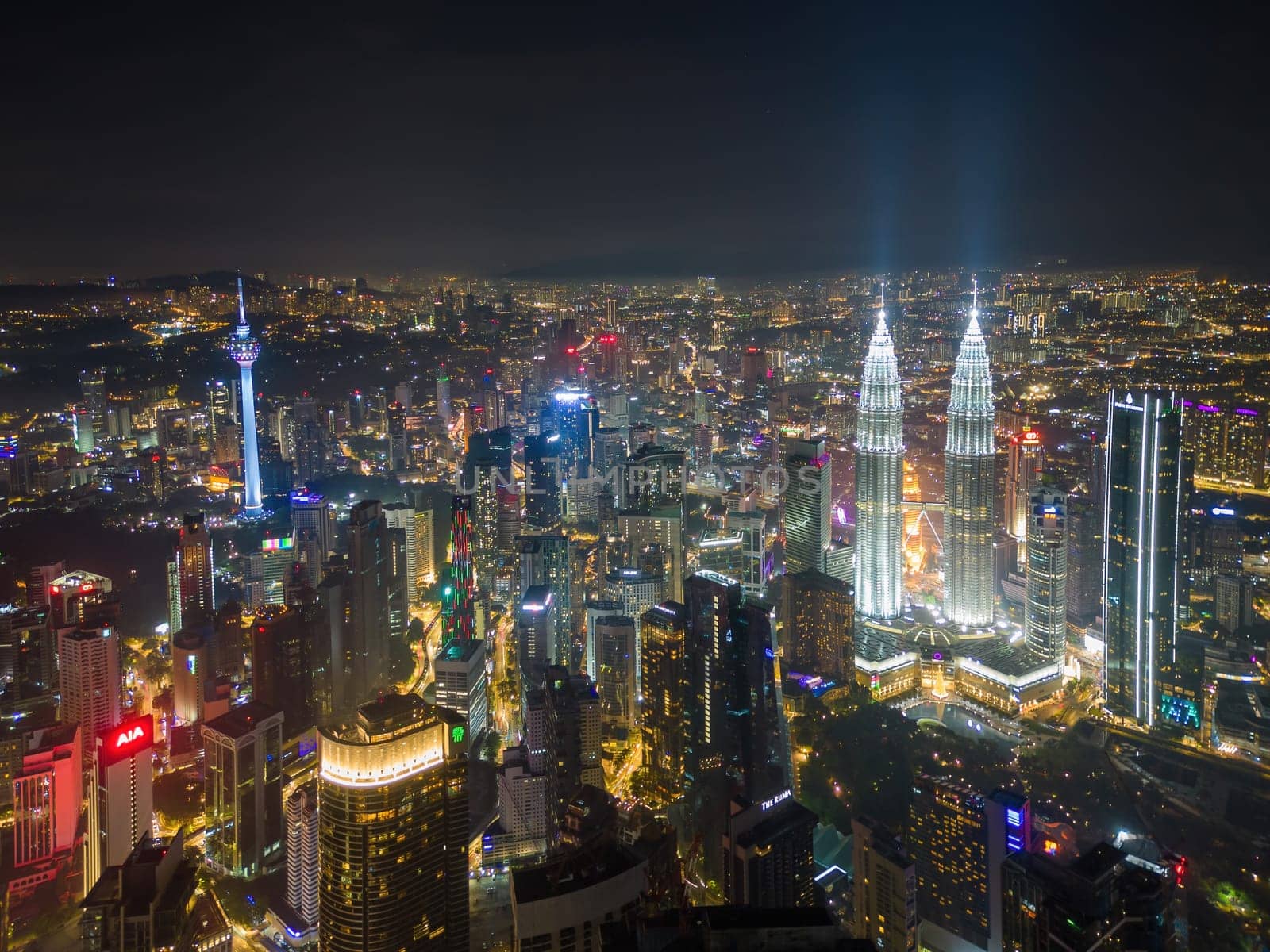 Bukit Bintang, Kuala Lumpur, Malaysia - Nov 29 2022: The Petronas Twin Towers stand tall, illuminated against the dark sky