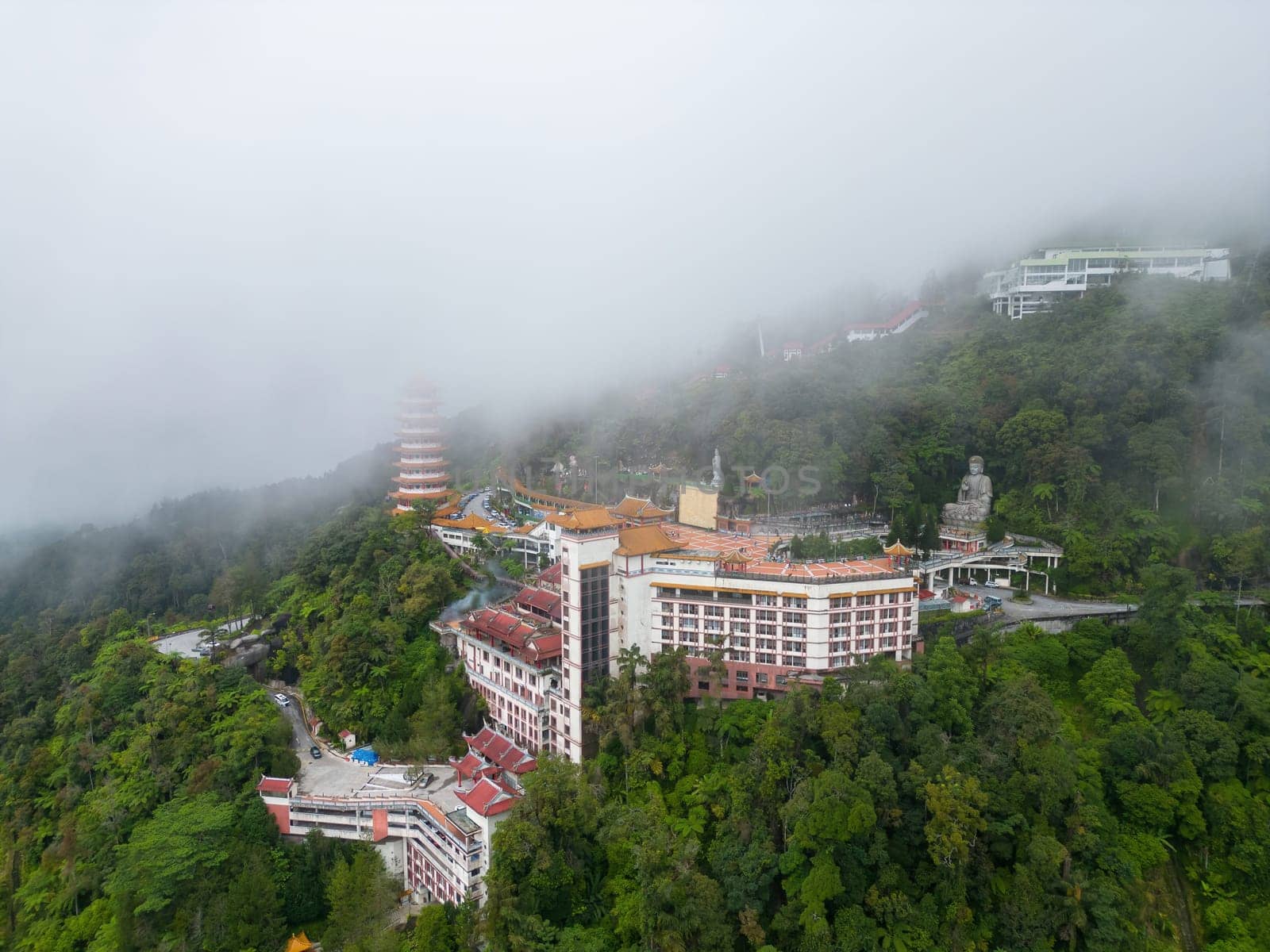 Genting, Pahang, Malaysia - Dec 04 2022: An aerial view of the Chin Swee Caves Temple and the surrounding trees and nestled amidst the clouds.