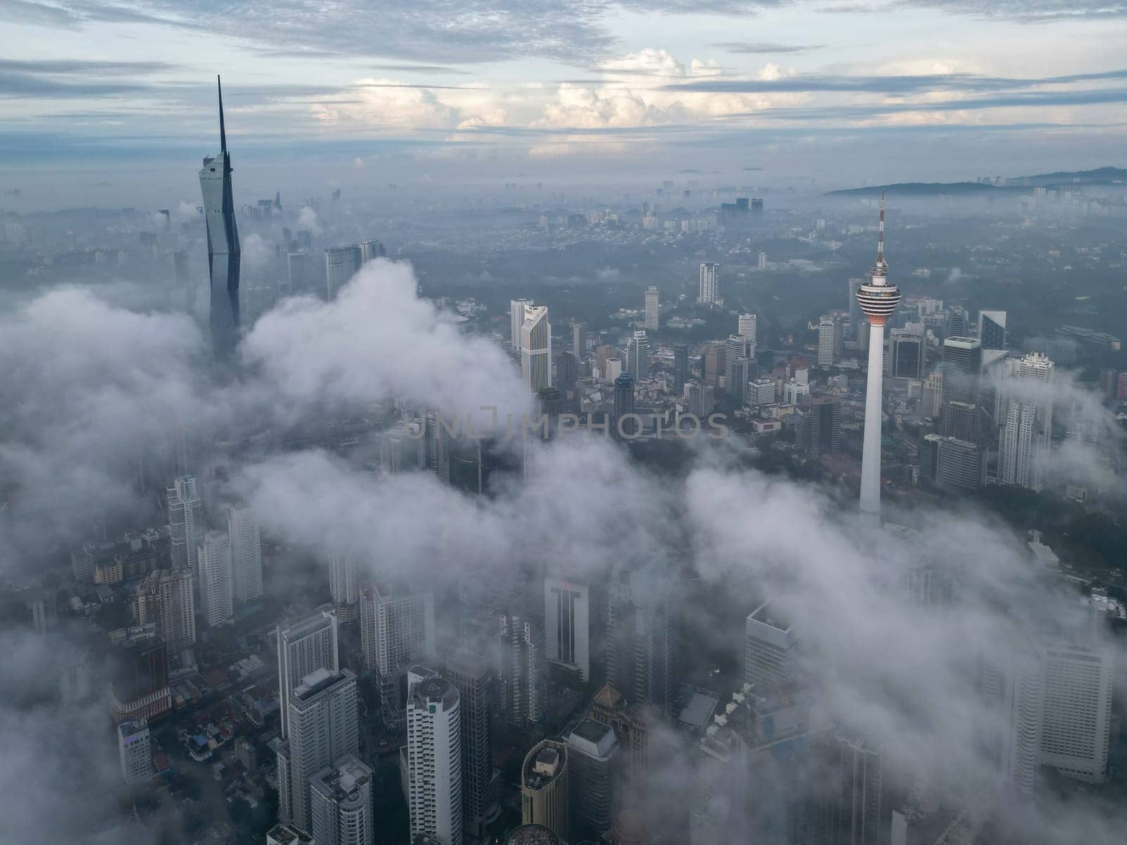 Bukit Bintang, Kuala Lumpur, Malaysia - Nov 13 2022: The low cloud cover creates a dramatic effect, highlighting the KL Tower and Merdeka 118 making it look larger than life.