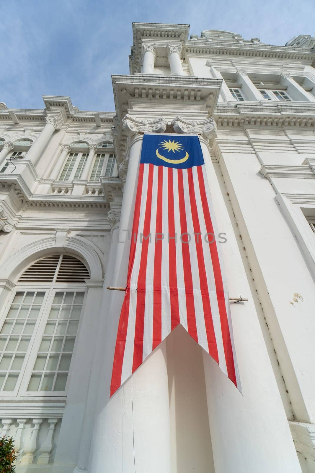 George Town, Penang, Malaysia - Aug 29 2022: Tilt up view Malaysia flag hang at wall outdoor