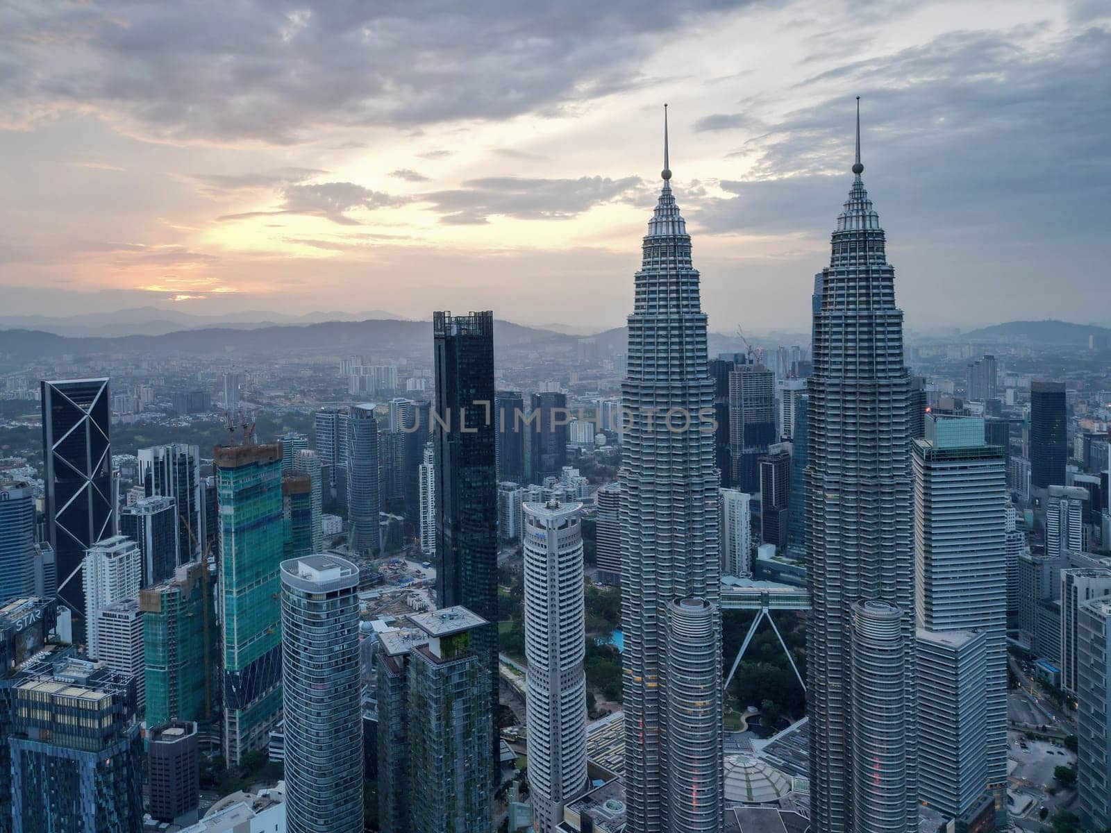 Bukit Bintang, Kuala Lumpur, Malaysia - Dec 25 2022: The city's iconic landmarks the KLCC Petronas Twin Towers in sunrise
