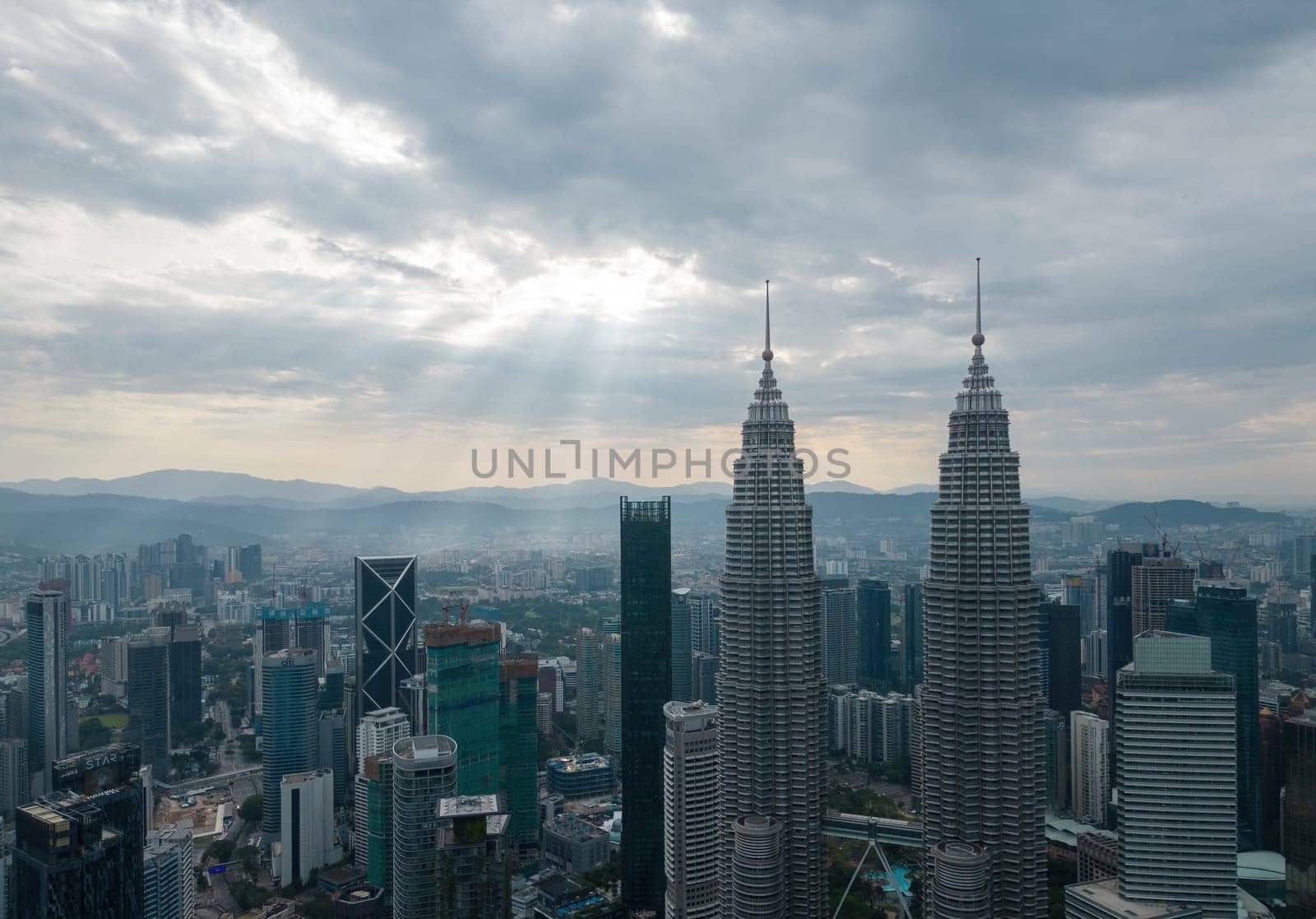 Bukit Bintang, Kuala Lumpur, Malaysia - Dec 25 2022: The city's iconic landmarks the Petronas Twin Towers in sun ray morning