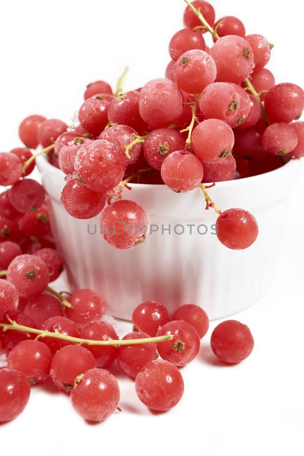 Frozen currants with stems in porcelain bowl