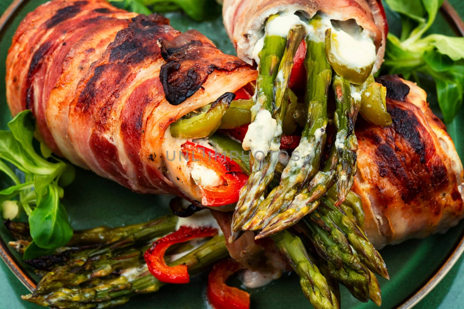 Meatloaf wrapped in bacon. Roasted green asparagus wrapped with meat . Top view