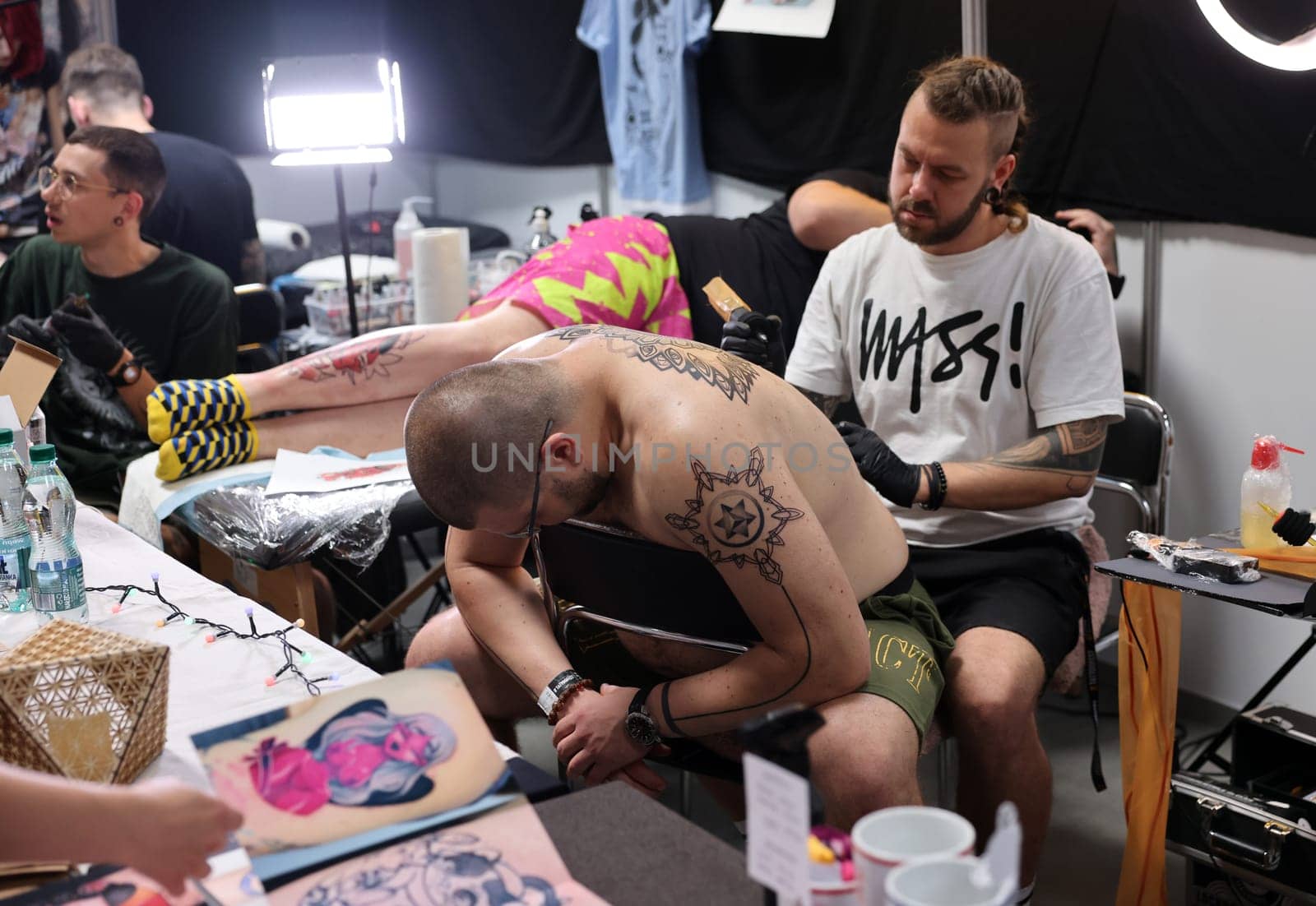 Krakow, Poland -  June 12, 2022: Unidentified  participant at 15th Tattoofest Convention in Cracow. One of the most prestigious tattoo festivals. Tattoo artist at work.