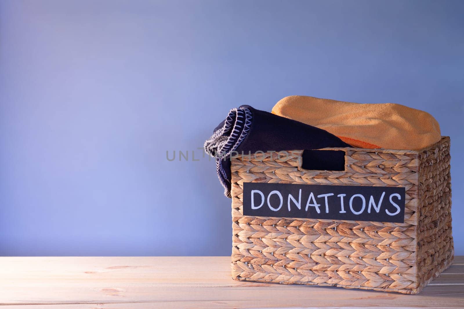 Donation box for clothing donations on a blue background, charity and donation concept. Copy space.
