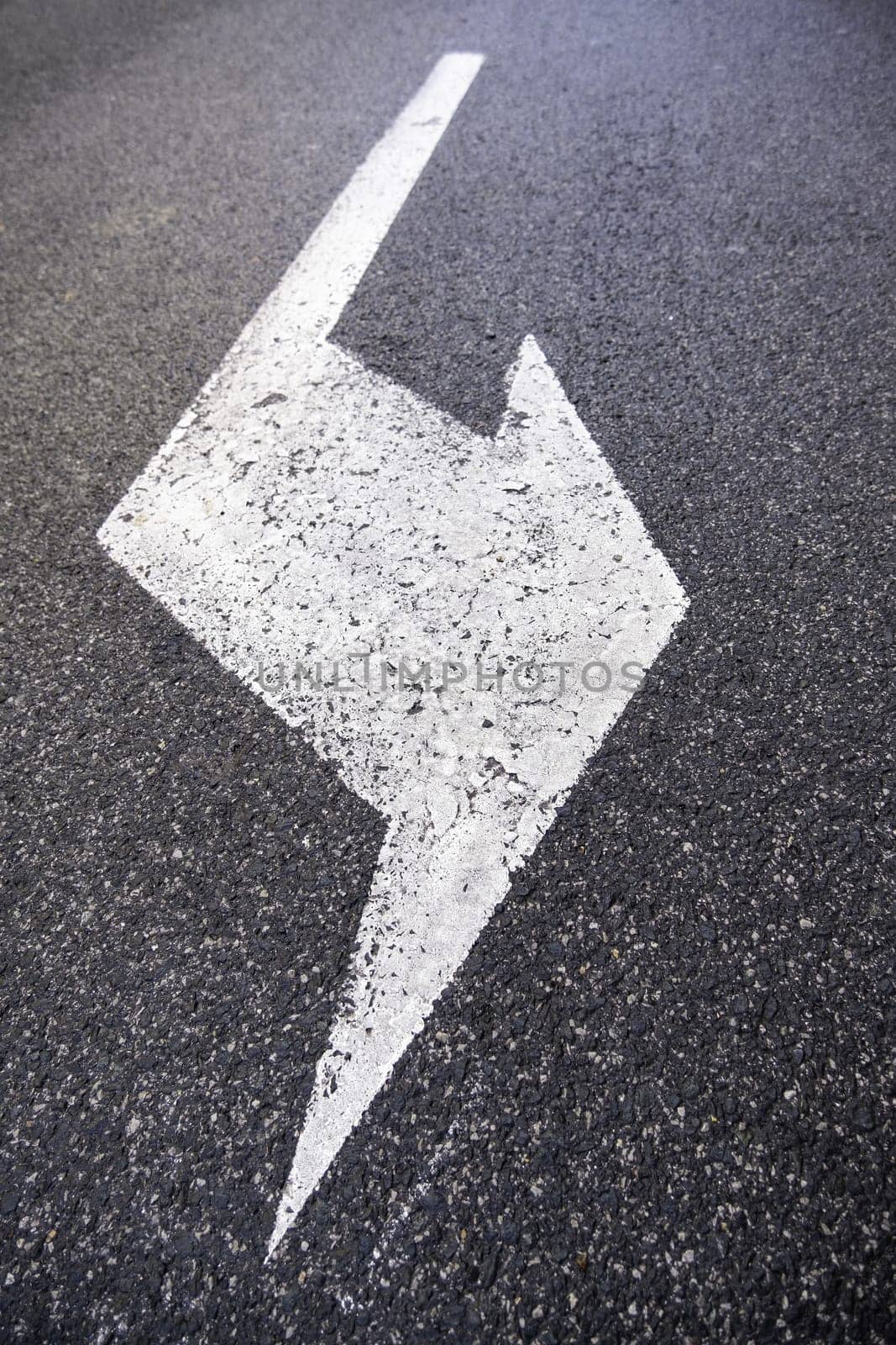 Detail of a traffic signal on a road, direction arrow and information